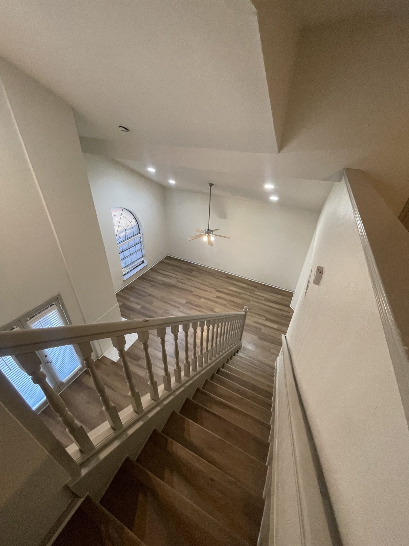 Two-story Vista Isle living room with vaulted ceiling and staircase